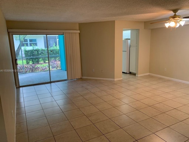 empty room with light tile floors, a textured ceiling, and ceiling fan