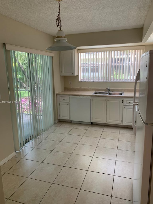 kitchen featuring plenty of natural light, white appliances, white cabinetry, and sink