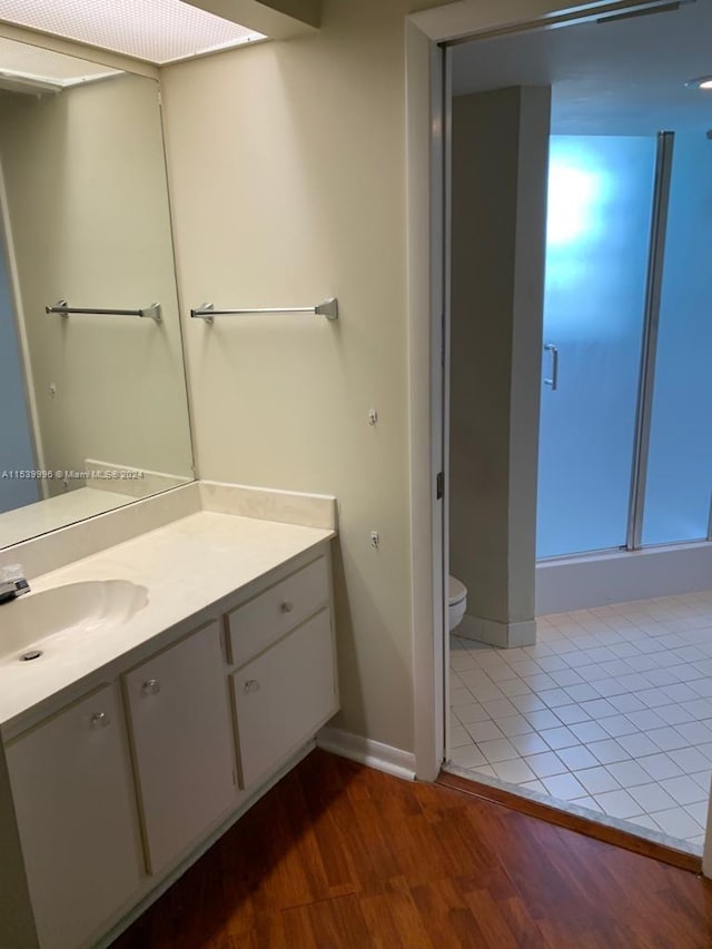 bathroom with tile flooring, vanity with extensive cabinet space, and toilet