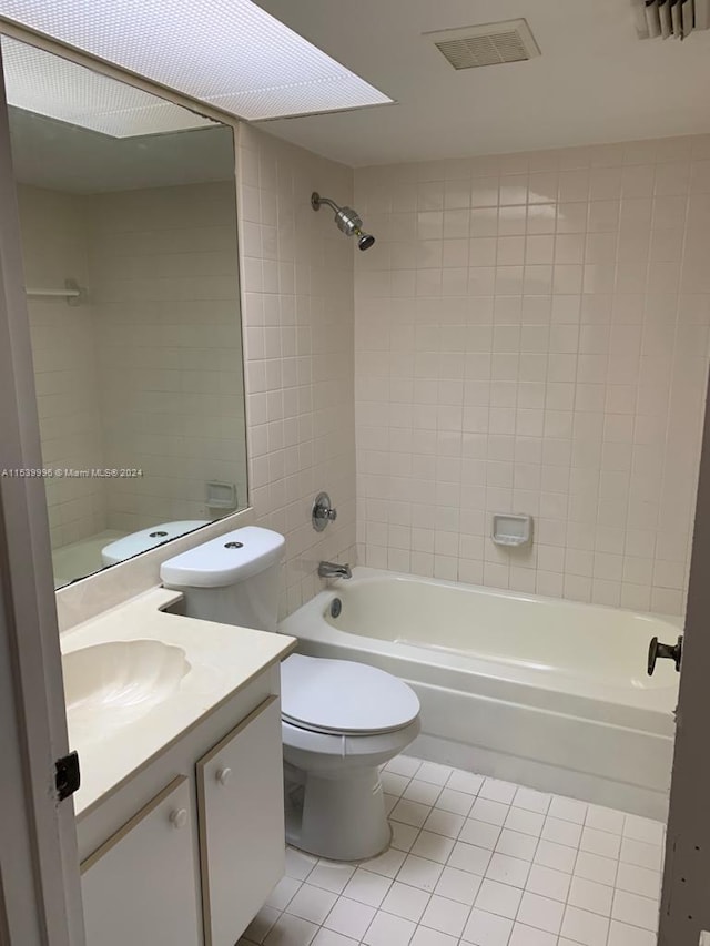 full bathroom featuring vanity, tile flooring, toilet, and tiled shower / bath