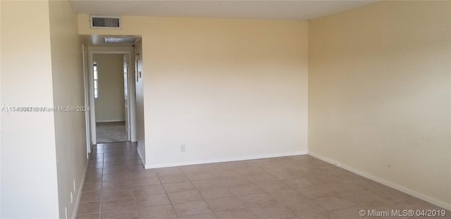 unfurnished room with light tile floors