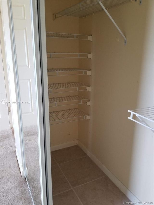 walk in closet featuring light tile floors