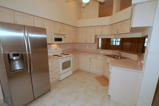 kitchen featuring a high ceiling, ceiling fan, white appliances, sink, and light tile floors