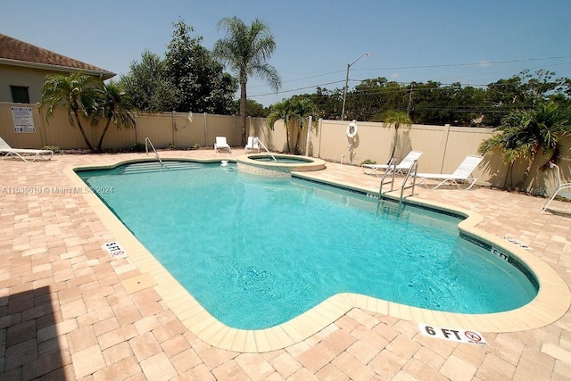 view of pool with a patio and a hot tub