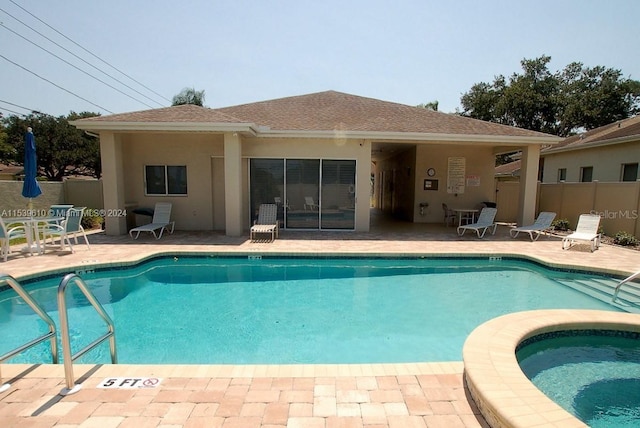 view of swimming pool featuring a patio area and a hot tub