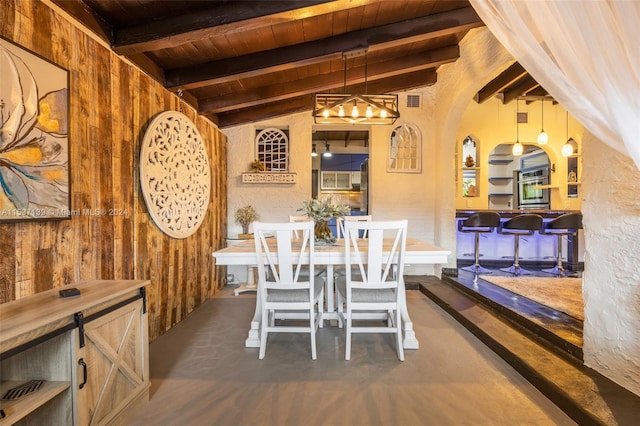 dining room featuring vaulted ceiling with beams, wood walls, and wooden ceiling