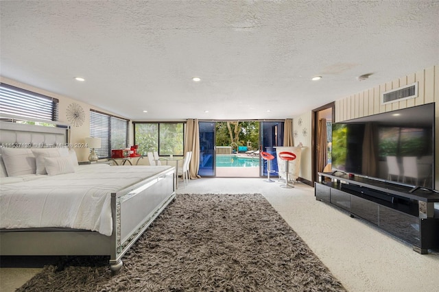 carpeted bedroom featuring access to outside and a textured ceiling