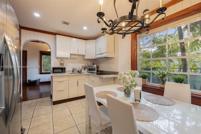 kitchen with light hardwood / wood-style flooring, stainless steel appliances, sink, a chandelier, and white cabinets