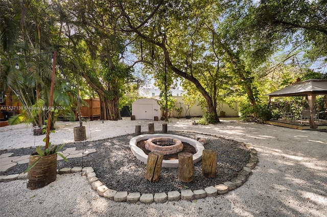 exterior space with a gazebo, a shed, and a fire pit