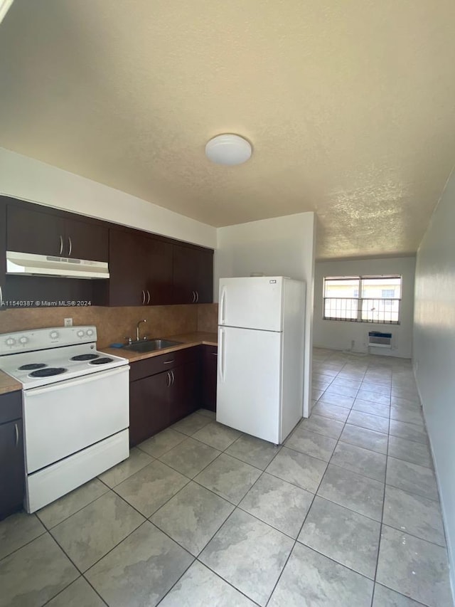 kitchen featuring white appliances, sink, light tile floors, a wall mounted air conditioner, and dark brown cabinetry