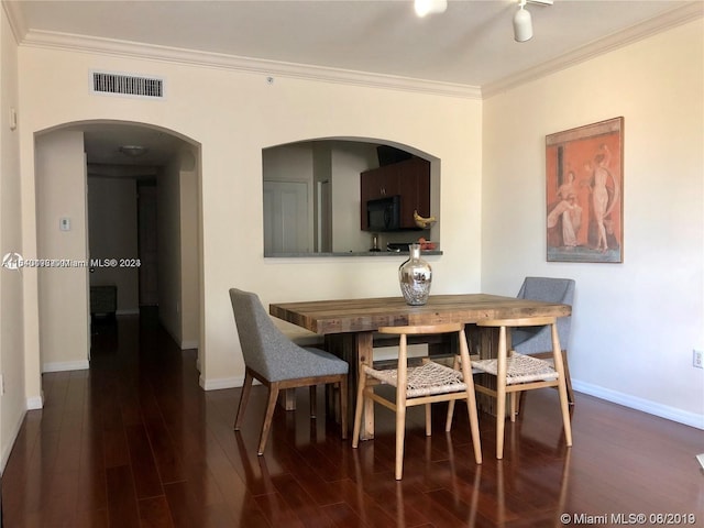 dining room featuring crown molding and dark hardwood / wood-style flooring