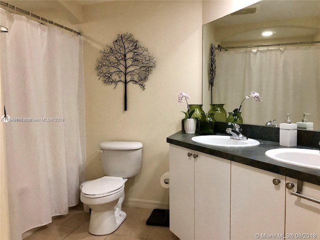 bathroom with toilet, tile flooring, and dual vanity