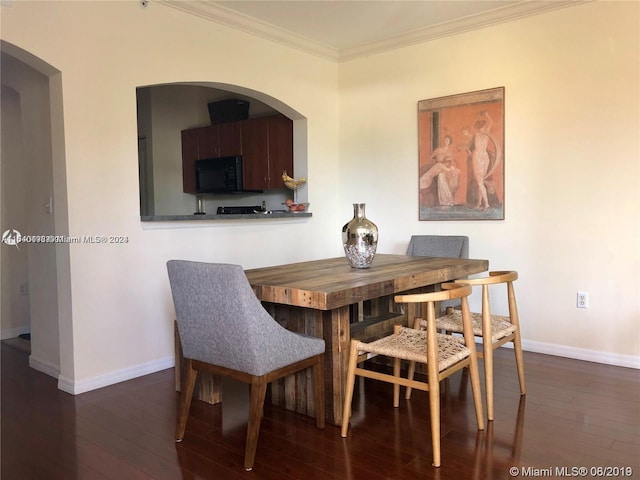 dining room with dark wood-type flooring and crown molding