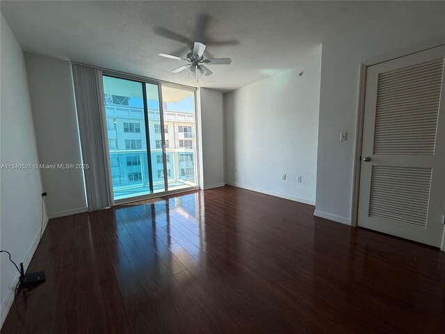 unfurnished living room featuring a textured ceiling, track lighting, and dark hardwood / wood-style floors