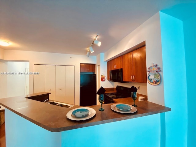 kitchen with sink, track lighting, black appliances, and kitchen peninsula