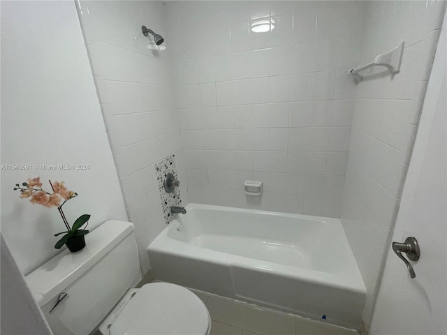 bathroom featuring toilet and tiled shower / bath