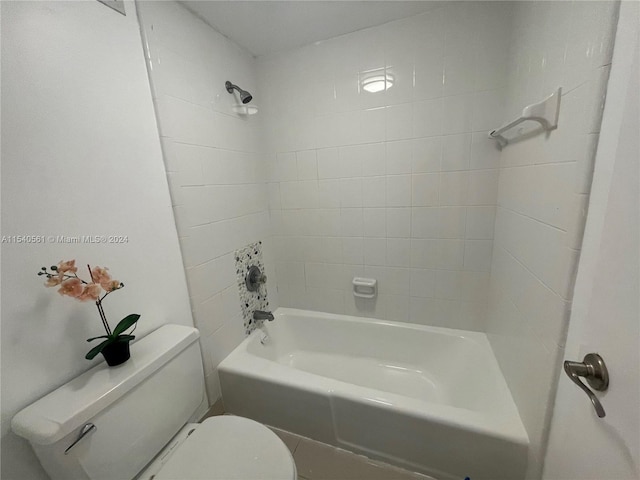 bathroom featuring tiled shower / bath and toilet