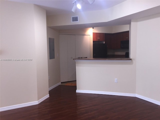 empty room featuring ceiling fan, rail lighting, and dark wood-type flooring