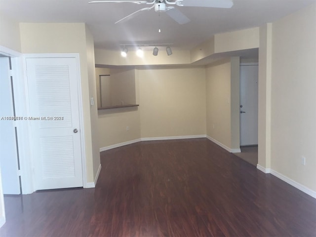 empty room featuring ceiling fan, track lighting, and dark hardwood / wood-style floors