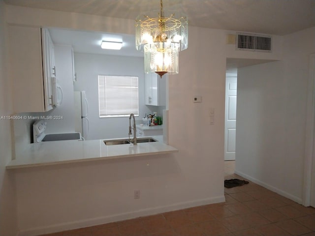 kitchen featuring tile patterned flooring, sink, an inviting chandelier, decorative light fixtures, and white appliances