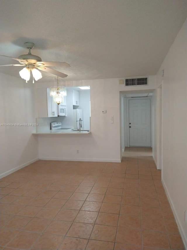 tiled spare room featuring ceiling fan and sink