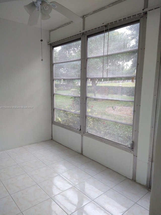 unfurnished sunroom with ceiling fan