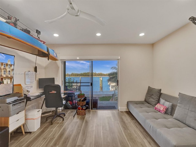 office area featuring light hardwood / wood-style floors and a water view