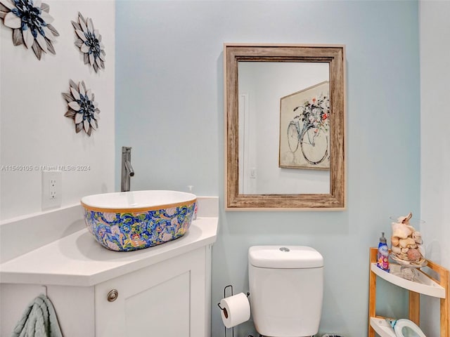 bathroom with toilet and large vanity