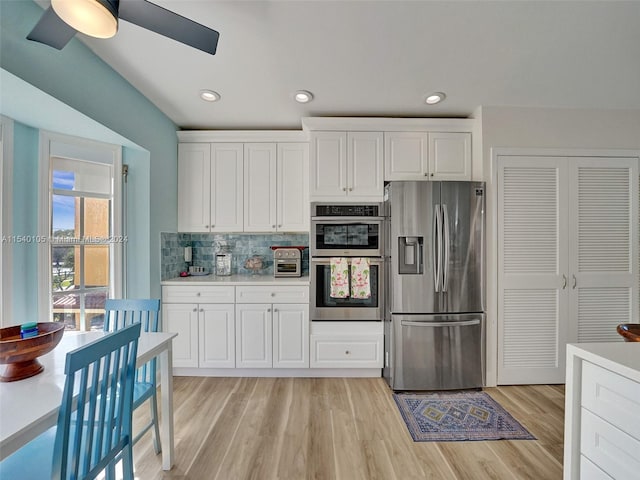 kitchen with ceiling fan, white cabinets, stainless steel appliances, tasteful backsplash, and light wood-type flooring