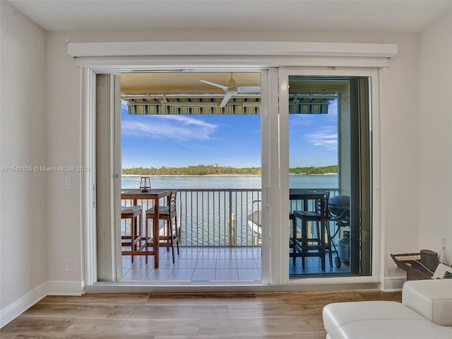 entryway with a water view, light hardwood / wood-style floors, and ceiling fan