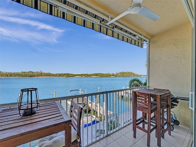 balcony with a water view and ceiling fan