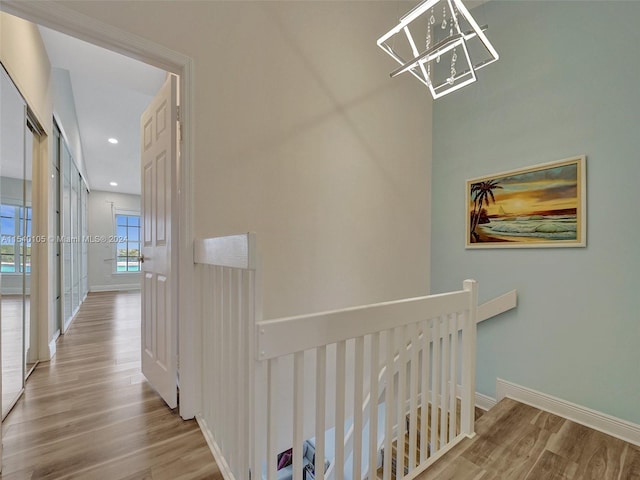 hall featuring a notable chandelier and light hardwood / wood-style flooring