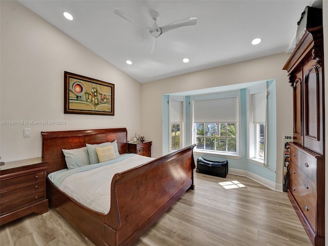 bedroom with vaulted ceiling, ceiling fan, and light wood-type flooring