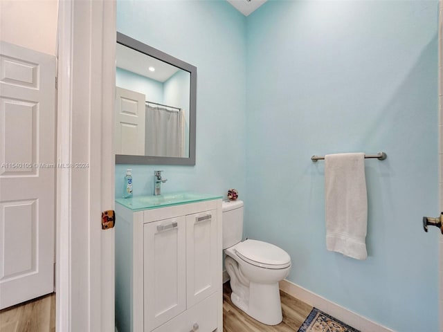 bathroom featuring vanity, wood-type flooring, and toilet