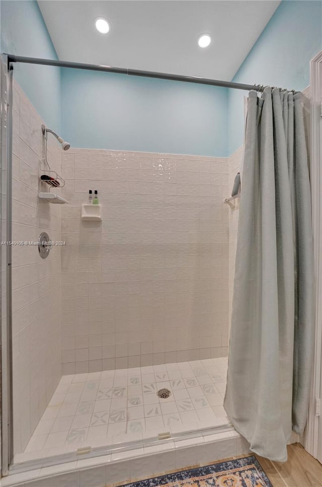 bathroom featuring walk in shower and wood-type flooring