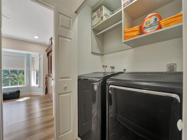 laundry area with washing machine and clothes dryer, hookup for a washing machine, hookup for an electric dryer, and hardwood / wood-style flooring