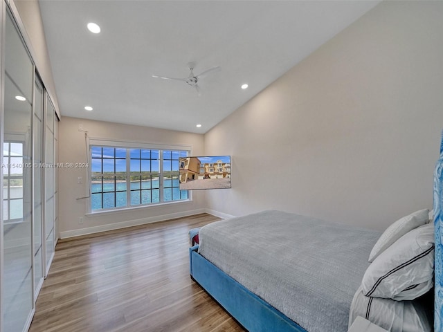 bedroom featuring multiple windows, ceiling fan, and light hardwood / wood-style flooring