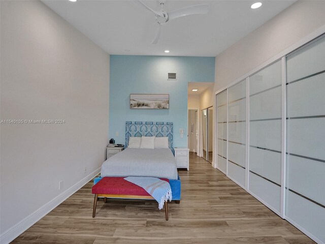 bedroom featuring ceiling fan, a closet, and light hardwood / wood-style flooring