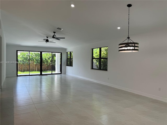 tiled empty room featuring ceiling fan