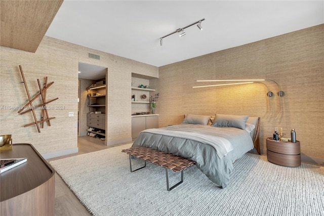 bedroom featuring rail lighting and light hardwood / wood-style floors