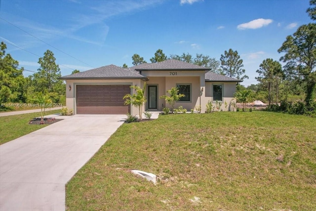 view of front of home with a front yard and a garage