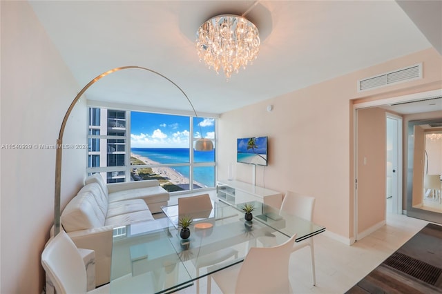 dining space featuring a water view, a wall of windows, a chandelier, and light hardwood / wood-style flooring