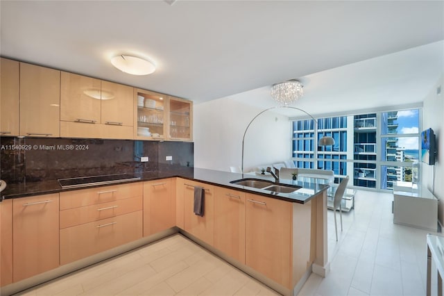 kitchen with kitchen peninsula, sink, black electric cooktop, tasteful backsplash, and light brown cabinets