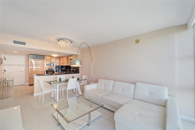 living room with an inviting chandelier and light hardwood / wood-style flooring