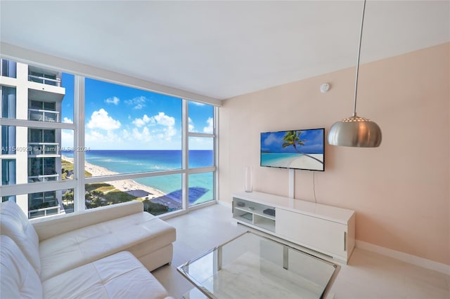 living room with floor to ceiling windows, a water view, and a wealth of natural light