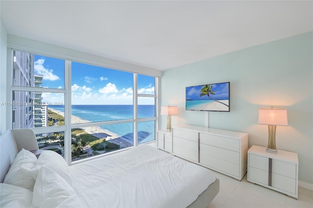 bedroom featuring a water view and floor to ceiling windows