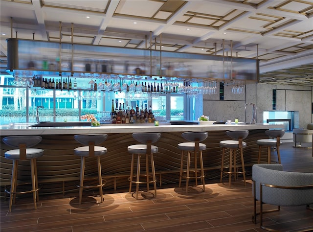 bar with coffered ceiling and dark hardwood / wood-style floors