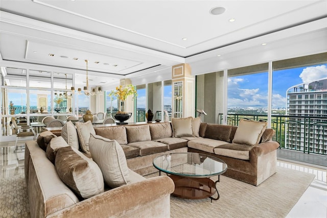 tiled living room featuring a wall of windows, a tray ceiling, and a notable chandelier