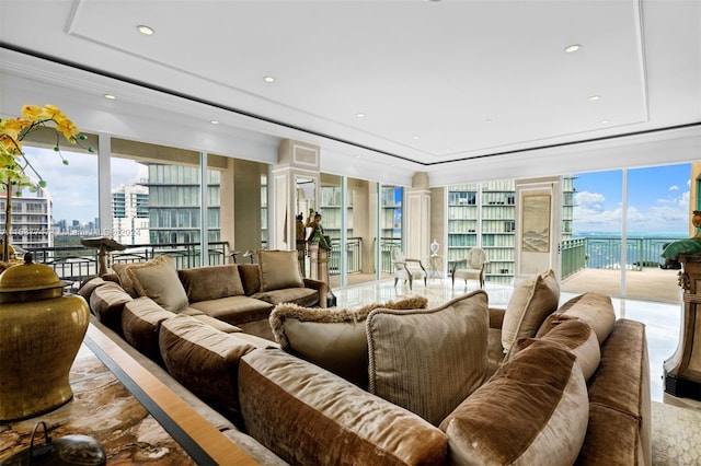 living room with floor to ceiling windows and a raised ceiling