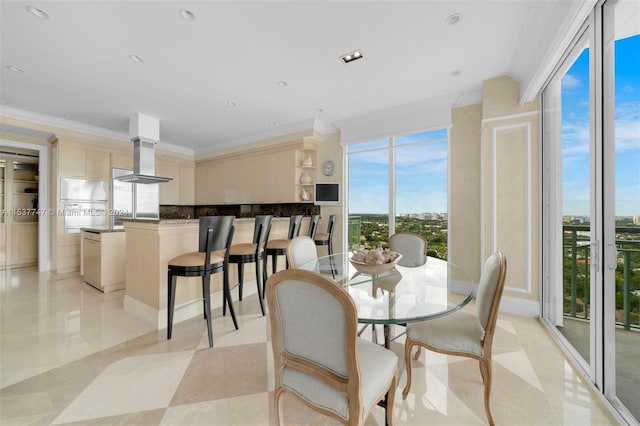 tiled dining space with plenty of natural light and ornamental molding